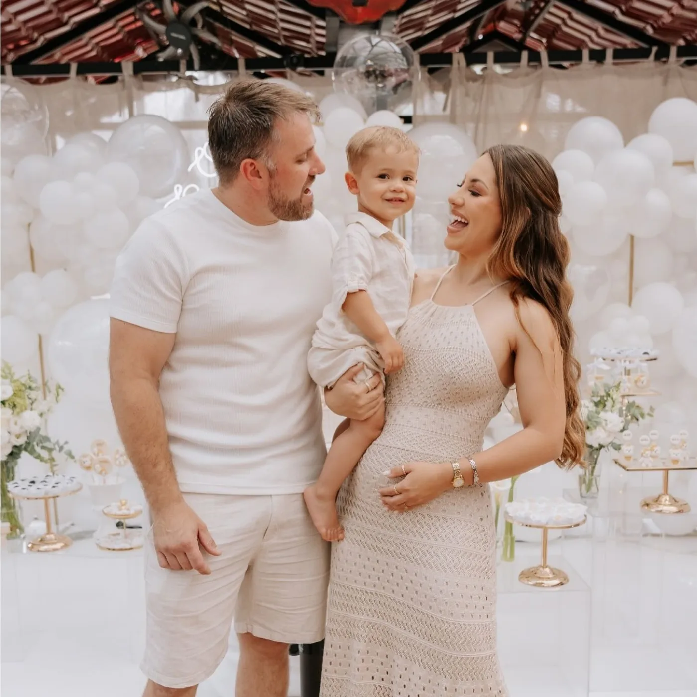 Pai e mãe com criança no colo celebrando primeiro aniversário