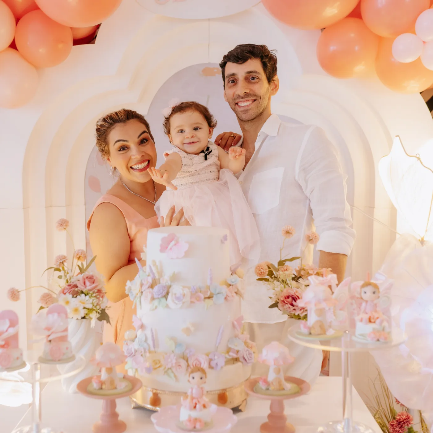 Criança soprando vela do bolo de aniversário com família ao redor